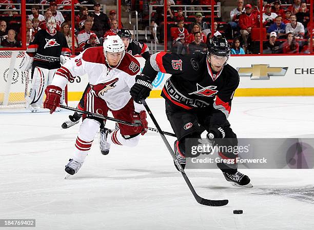 Tuomo Ruutu of the Carolina Hurricanes skates with the puck past Rob Klinkhammer of the Phoenix Coyotes during their NHL game at PNC Arena on October...