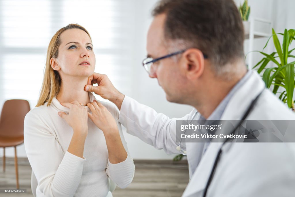 Male doctor examining female patient at the doctors office