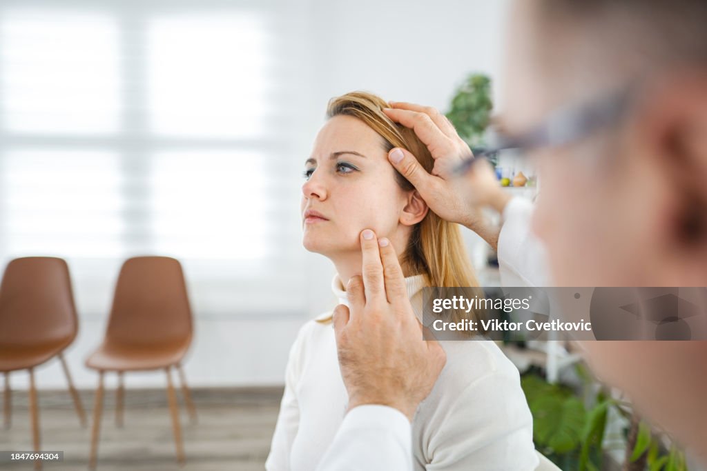 Male doctor examining female patient at the doctors office