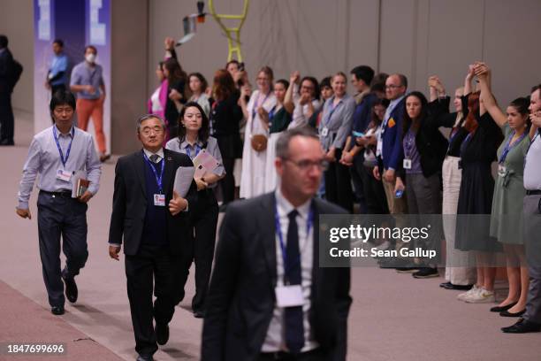 Participants hold raised hands as heads of delegations, including Liu Zhenmin , Chinese climate enovoy, arrive for negotiations over the wording of...