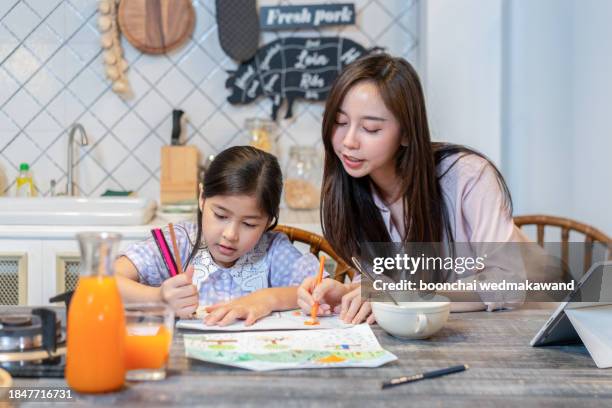 loving young mother and little preschooler daughter sit at table drawing on paper together, caring mum or nanny playing with small girl child, paint pictures in notebook, early development concept - single line drawing woman stock pictures, royalty-free photos & images