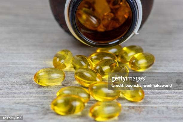 cod liver oil omega 3 gel capsules isolated on wooden background - omega 3 bildbanksfoton och bilder