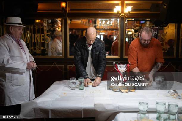 Publican and official 'Piemaster' Tony Callaghan looks on as competitors Ian Coulton and Martin Appleton-Clare take part in a 'pie-off', following a...