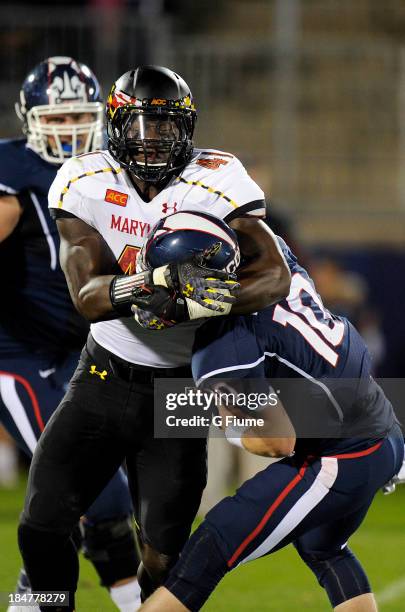 Chandler Whitmer of the Connecticut Huskies is sacked by Marcus Whitfield of the Maryland Terrapins at Rentschler Field on September 14, 2013 in East...