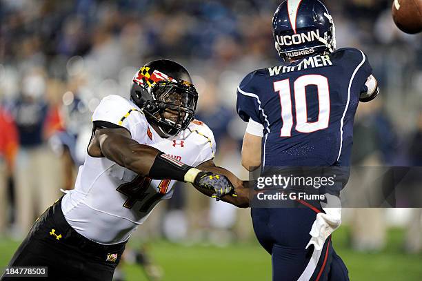 Chandler Whitmer of the Connecticut Huskies is pressured by Marcus Whitfield of the Maryland Terrapins at Rentschler Field on September 14, 2013 in...
