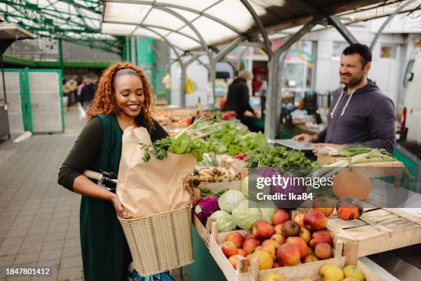 schöne mittelerwachsene frau, die auf nachhaltige weise lebensmittel einkaufen geht - fahrradkorb stock-fotos und bilder