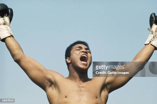 World Heavyweight boxing champion Muhammad Ali raises his arms and shouts during training on 10 July 1972 for his fight with Al 'Blue' Lewis held at...