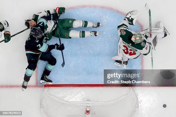 Jared Spurgeon of the Minnesota Wild is checked by Jordan Eberle of the Seattle Kraken during the third period at Climate Pledge Arena on December...