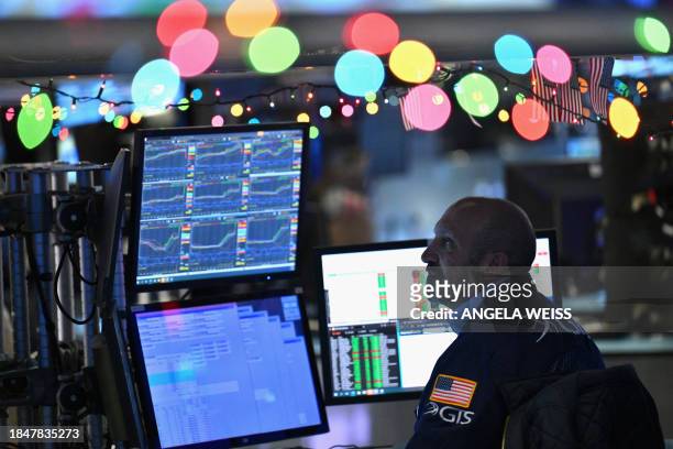 Traders work on the floor of the New York Stock Exchange during morning trading on December 14 in New York City.