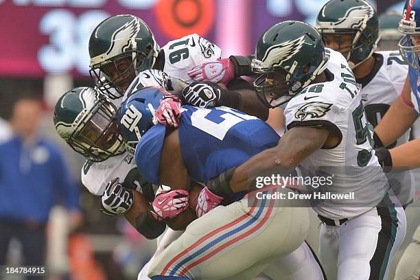 David Wilson of the New York Giants gets tackled by Earl Wolff, Fletcher Cox and Trent Cole of the Philadelphia Eagles at MetLife Stadium on October...