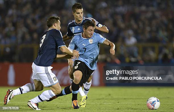 Argentina's Erik Lamela and Hugo Campagnaro vie for the ball with Uruguayan midfielder Cristian Rodriguez during their Brazil 2014 FIFA World Cup...