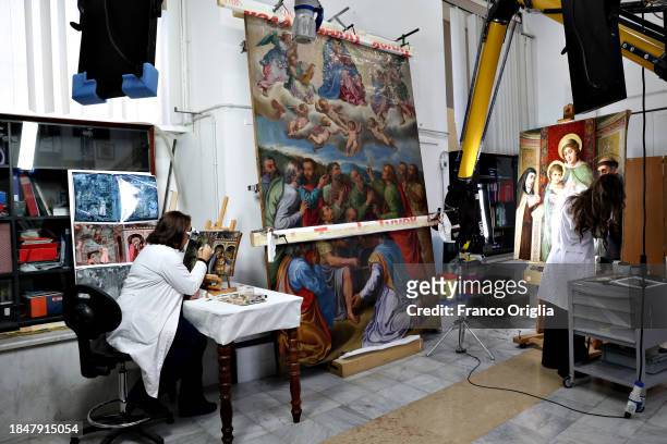 Restorers work on a painting at Vatican Museums Restoration Laboratory during “Beyond the surface. The restorer's gaze": the exhibition initiative...