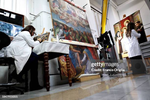 Restorers work on a painting at Vatican Museums Restoration Laboratory during “Beyond the surface. The restorer's gaze": the exhibition initiative...