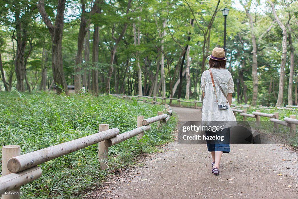 The girl walking among park trees