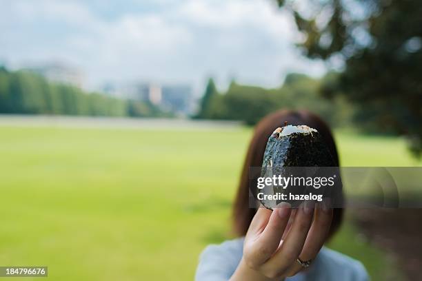 woman hold out a riceball - rice ball stock pictures, royalty-free photos & images