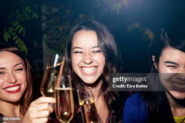 friends drinking champagne at a party. - brown hair drink wine stock-fotos und bilder