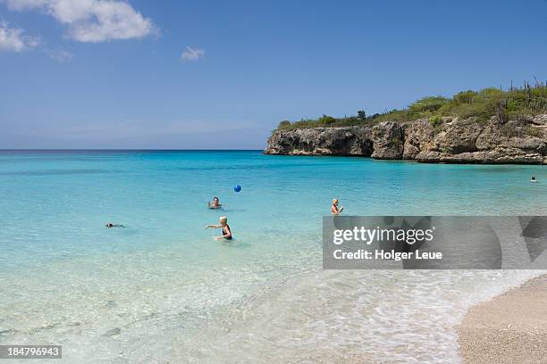 people swim and play ball at grote knip beach - knip beach stock pictures, royalty-free photos & images