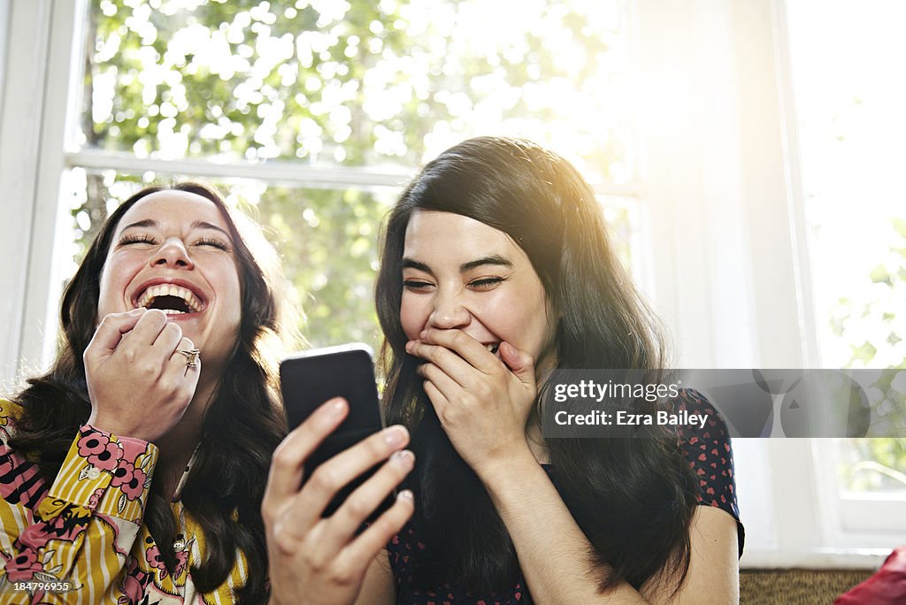 Friends laughing at a mobile phone