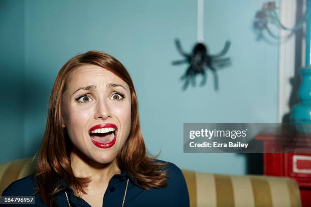 shocked woman looking at spider. - panic attack stock-fotos und bilder