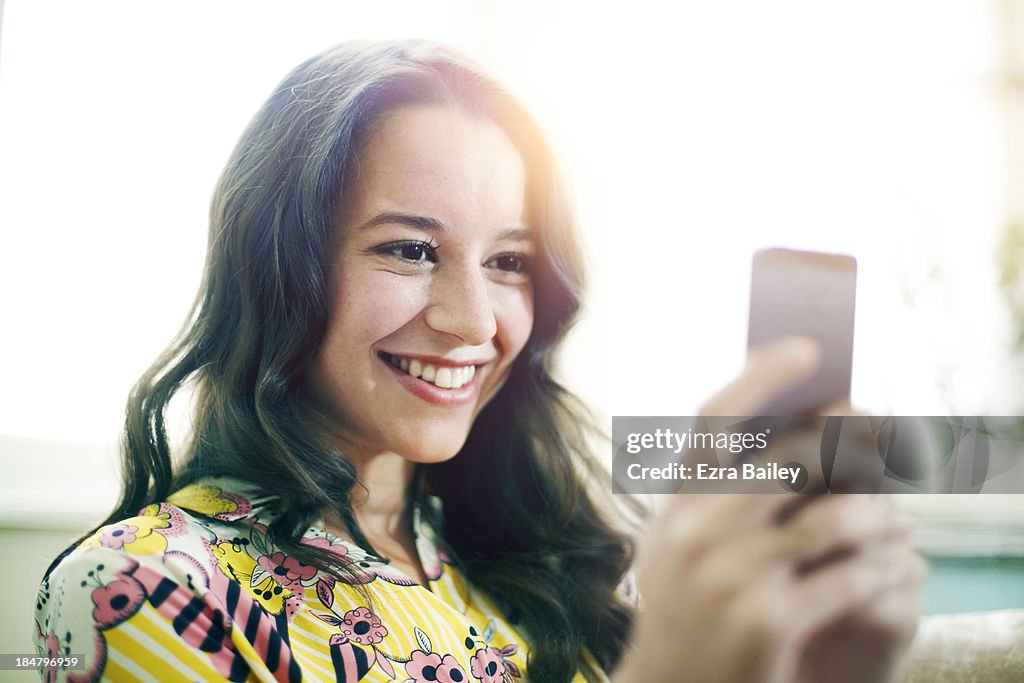 Woman smiling and using her mobile phone.