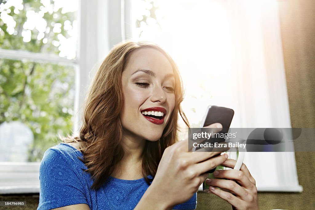 Woman using her phone and smiling