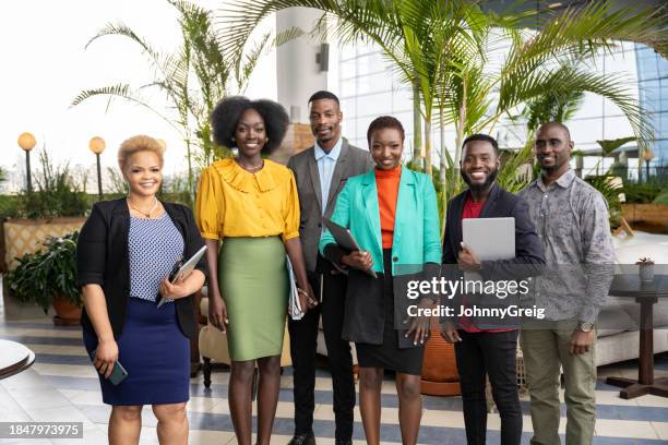 cheerful project team standing together in office atrium - nairobi stock pictures, royalty-free photos & images