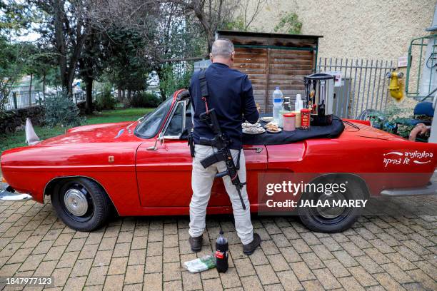 Man snacks on pastries placed atop an open-top vehicle during an event donating emergency and first aid packs by the International Fellowship of...