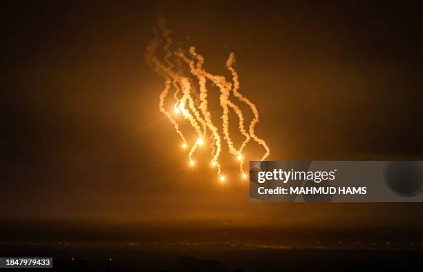 Picture taken from Rafah shows flares lighting the skies over Khan Yunis in the southern Gaza Strip during Israeli strikes, on December 14 amid...