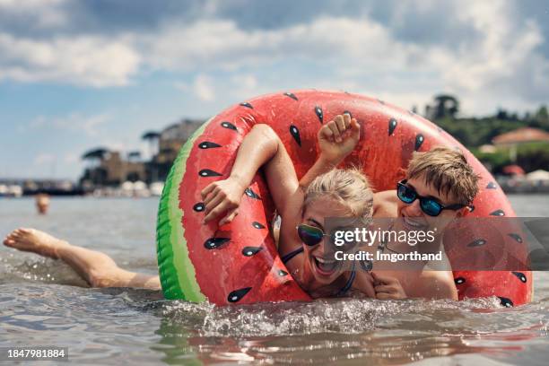 teenagers playing in sea on a sunny summer day - teenager tube stock pictures, royalty-free photos & images