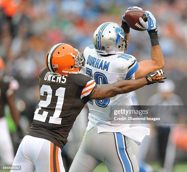 Receiver Kris Durham of the Detroit Lions catches a pass while defensive back Chris Owens of the Cleveland Browns attempts to tackle him during a...