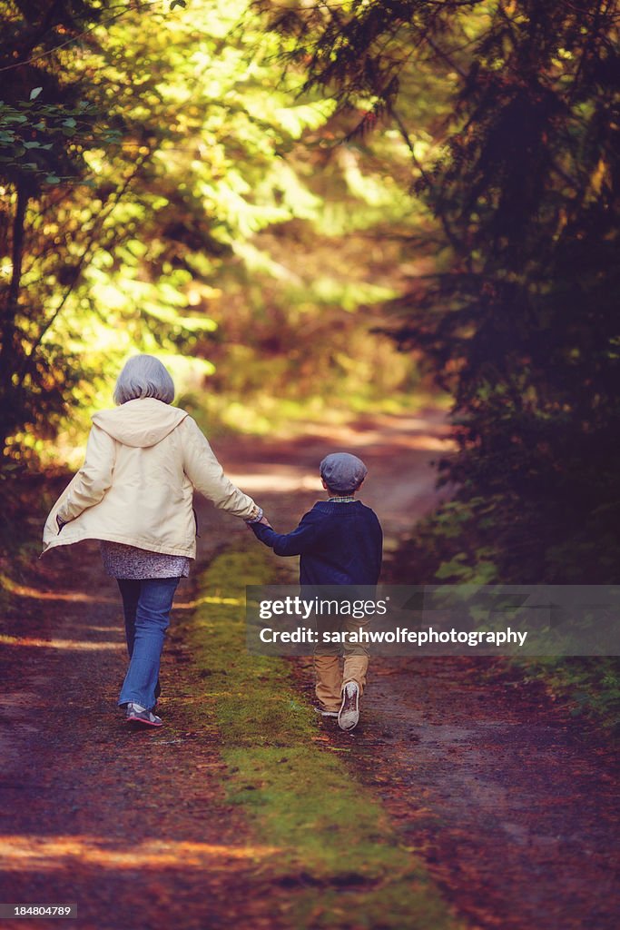 Older woman and child walking down mossy road