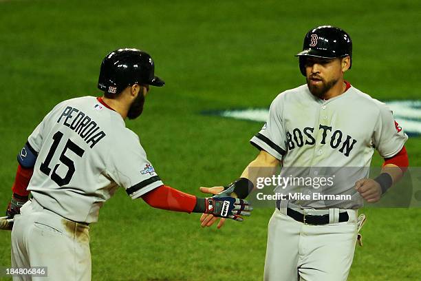 Jacoby Ellsbury celebrates scoring on a double by Shane Victorino with Dustin Pedroia of the Boston Red Sox in the seventh inning against the Detroit...