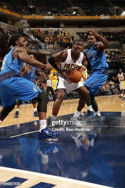 Ian Mahinmi of the Indiana Pacers drives against Bernard James of the Dallas Mavericks at Bankers Life Fieldhouse on October 16, 2013 in...