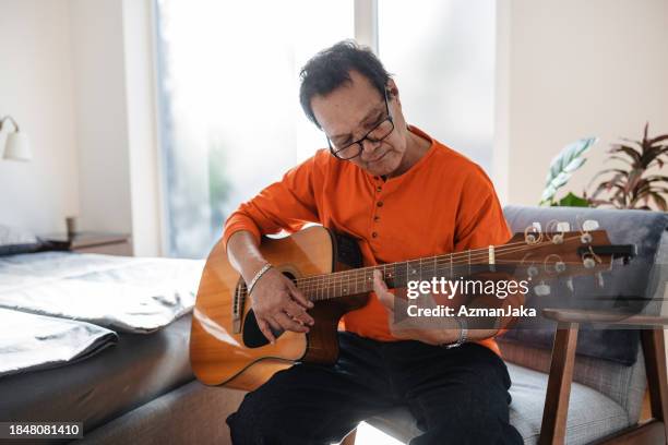 man learning guitar - asian musician stock pictures, royalty-free photos & images