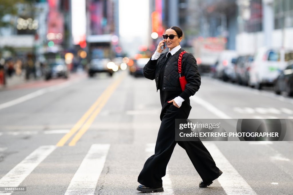 Fashionably dressed female business person seen on the street of New York talking on the phone and smiling