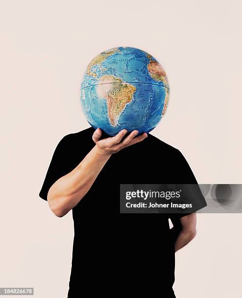 man holding globe in front of face - world war 1 stock-fotos und bilder