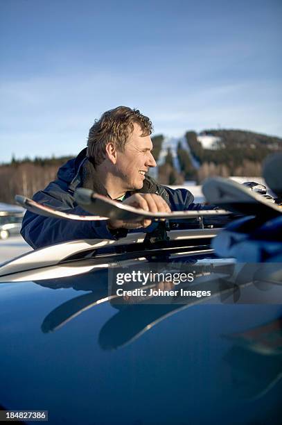 man unloading skis from roof rack - dalarna winter stock-fotos und bilder