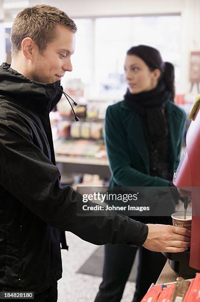 young couple having coffee at gas station - inside coffe store stock-fotos und bilder