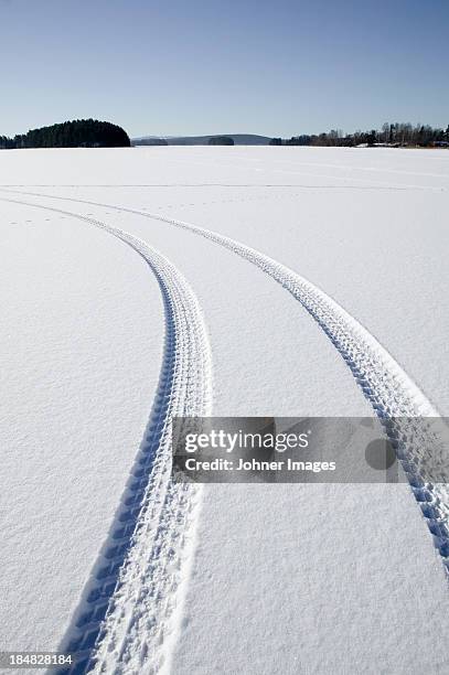 tire track on snowy landscape - tyre track stock pictures, royalty-free photos & images