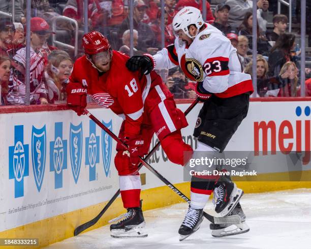 Andrew Copp of the Detroit Red Wings battles along the boards with Travis Hamonic of the Ottawa Senators during the third period at Little Caesars...