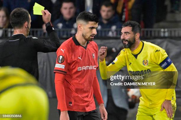 Turkish referee Atilla Karaoglan gives a yellow card to Villarreal's Spanish defender Raul Albiol during the UEFA Europa League group F football...