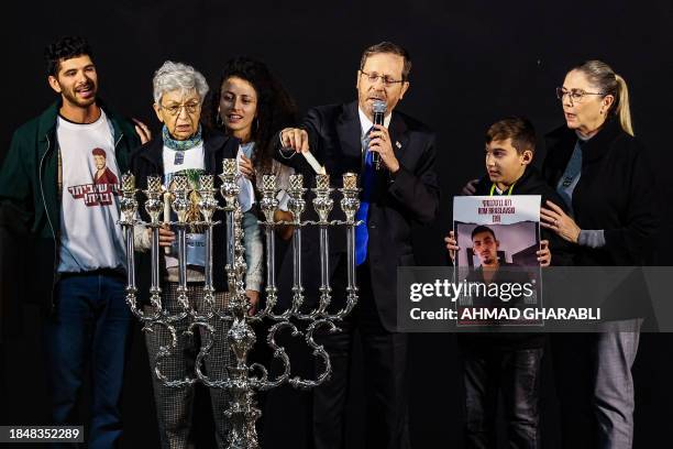 Israel's President Isaac Herzog and his wife first lady Michal Herzog assist the family members of one of the hostages held by Palestinian militants...