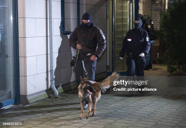 December 2023, Berlin: Police officers with a dog go to a house. The Federal Public Prosecutor's Office has arrested four suspected members of the...