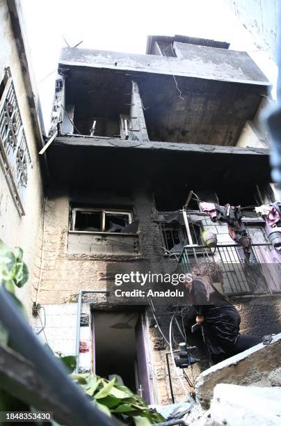 People are around a destroyed house which has walls covered with burn marks due to highly flammable explosives Israeli forces use in attacks at the...