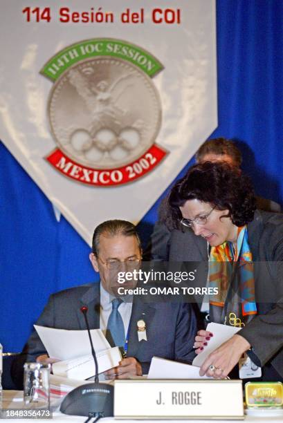 International Olympic Committee President Jacques Rogge speaks with one of its assistants during the final day, 29 November 2002, of the 11th IOC...