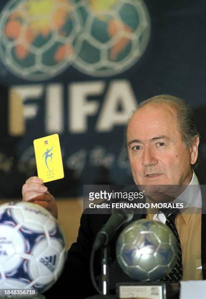 The President of FIFA, Joseph Blatter, shows a yellow card as he talks about to the violence in soccer during a press conference in Guatemala City,...