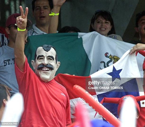 Panamanian fan with a mask of Mexican President-elect Vicente Fox, makes the V sign for victory, 16 July 2000, in Panama City. Panama defeated Mexico...
