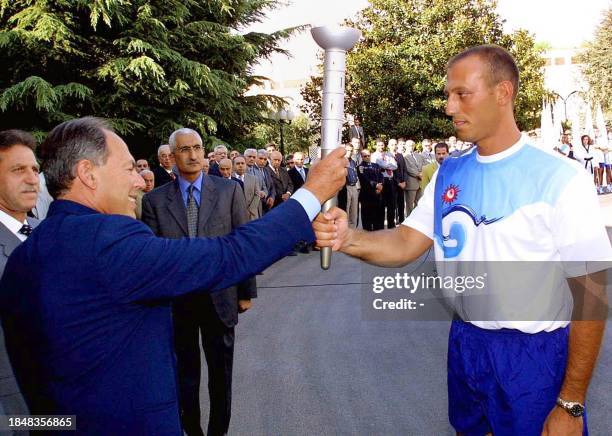 Lebanese President Emile Lahoud handsover 05 September 2002 the Olympic flame to Lebanese officer George Honien at the Baabda Presidential Palace...