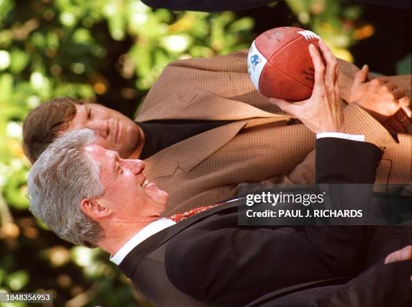 Bill Clinton Playing Rugby US President Bill Clinton looks at a football given him by the Green ...