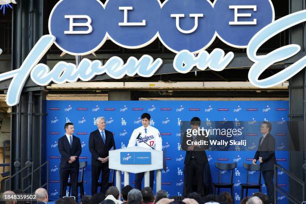 Shohei Ohtani, center, speaks on the stage with, from left, president of baseball operations Andrew Friedman, owner Mark Walter, Shohei Ohtani, and...